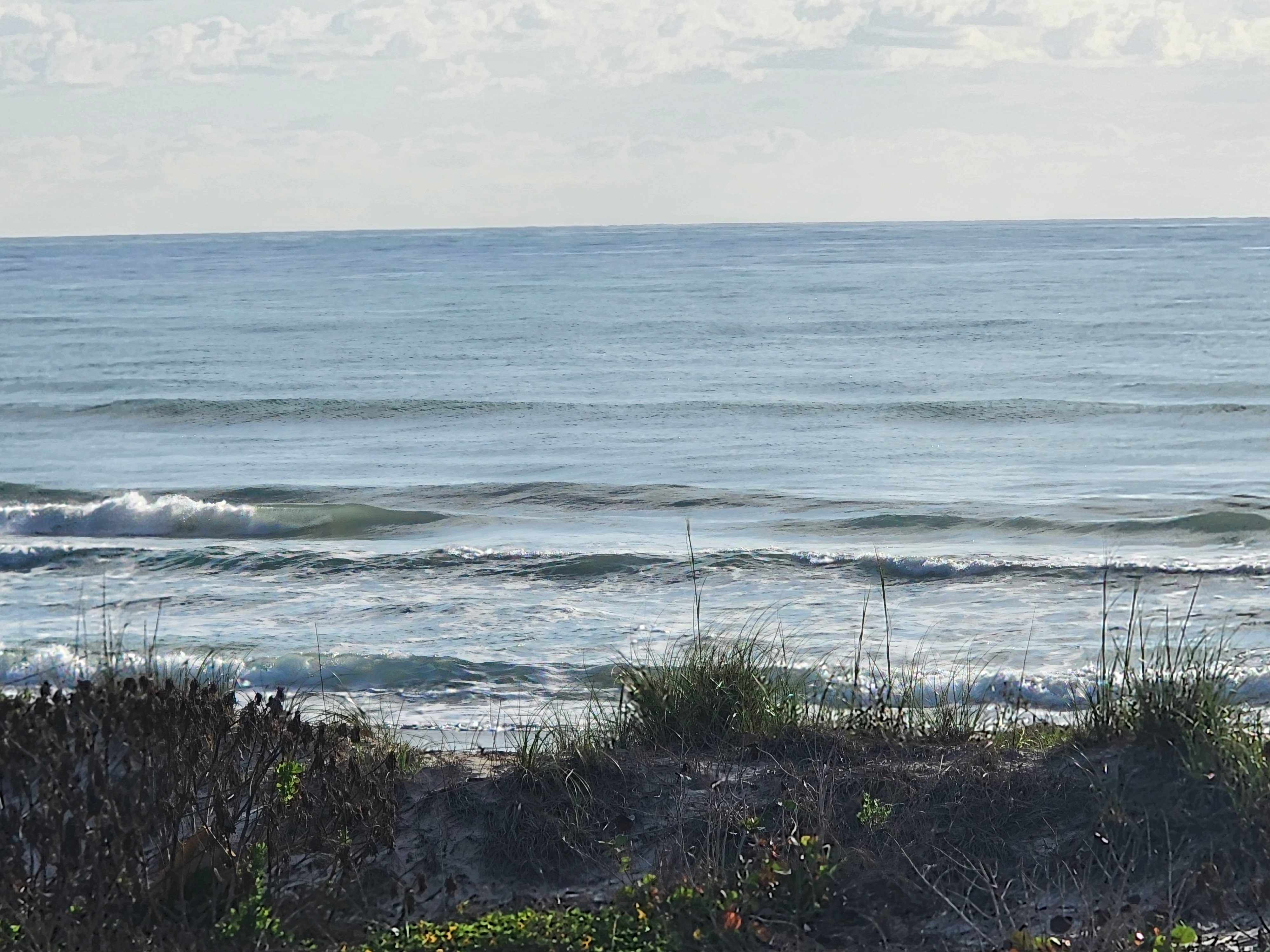 Clean 1-2 foot morning surf with light W winds at Picnic Tables South Cocoa Beach April 24 2026