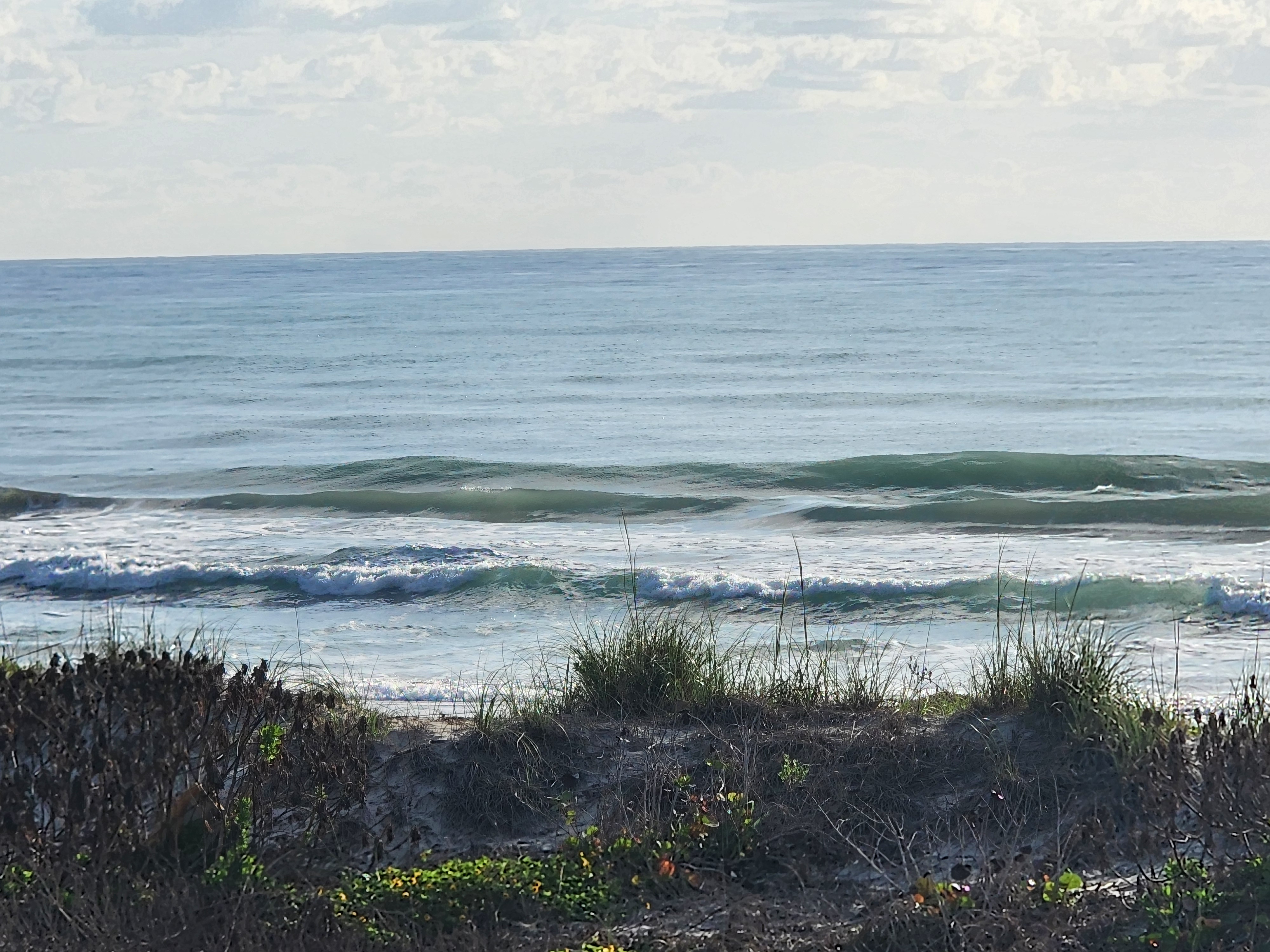 Small clean wave breaking nearshore at 31st Street Cocoa Beach morning light
