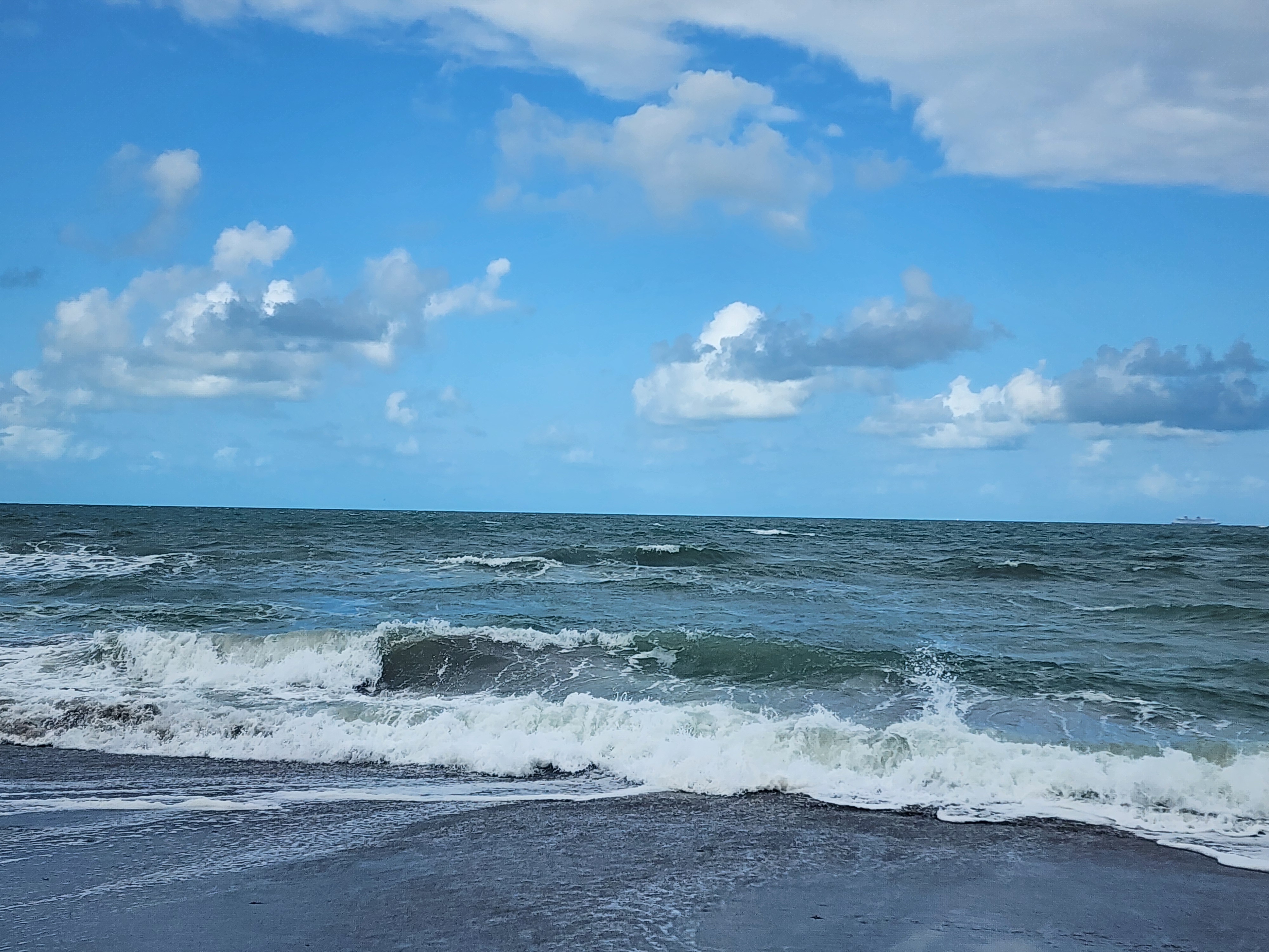 Flat 1 foot afternoon surf breaking into shore at Picnic Tables South Cocoa Beach April 27 2026