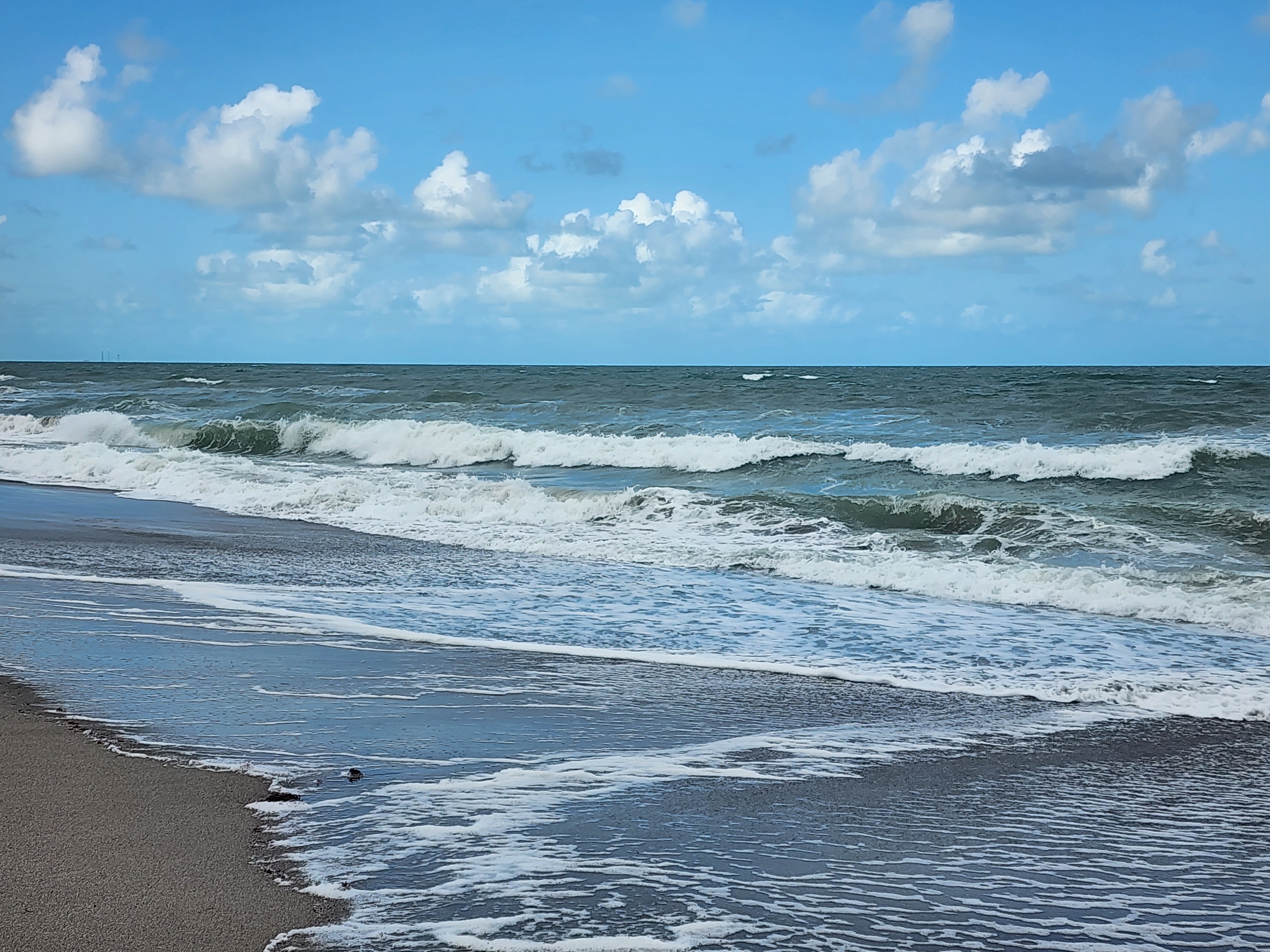 Beach day scene with flat 1 foot surf at Picnic Tables South Cocoa Beach sunny afternoon