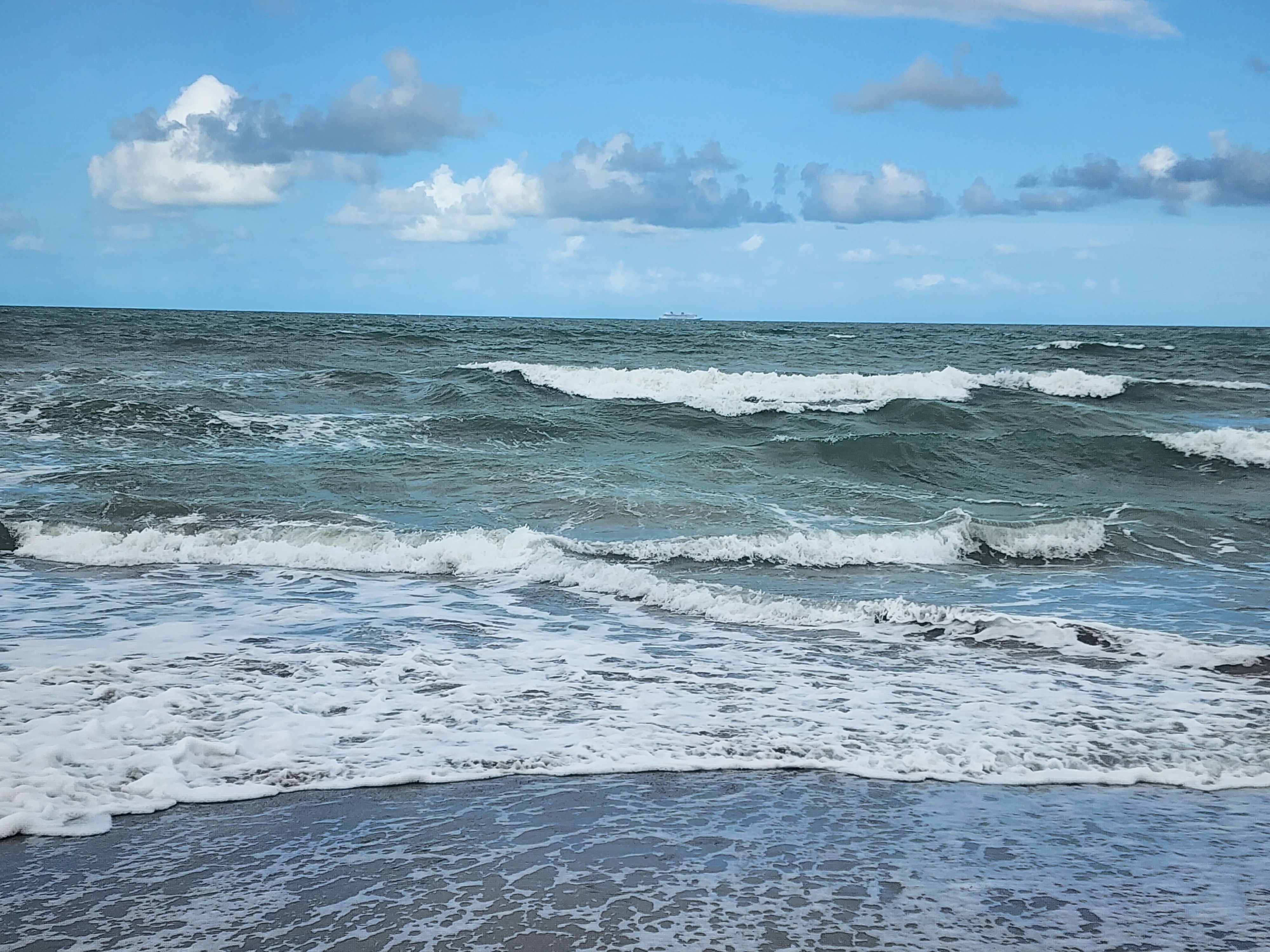 Afternoon sun on flat calm ocean with 1 foot shore break at Picnic Tables South Cocoa Beach