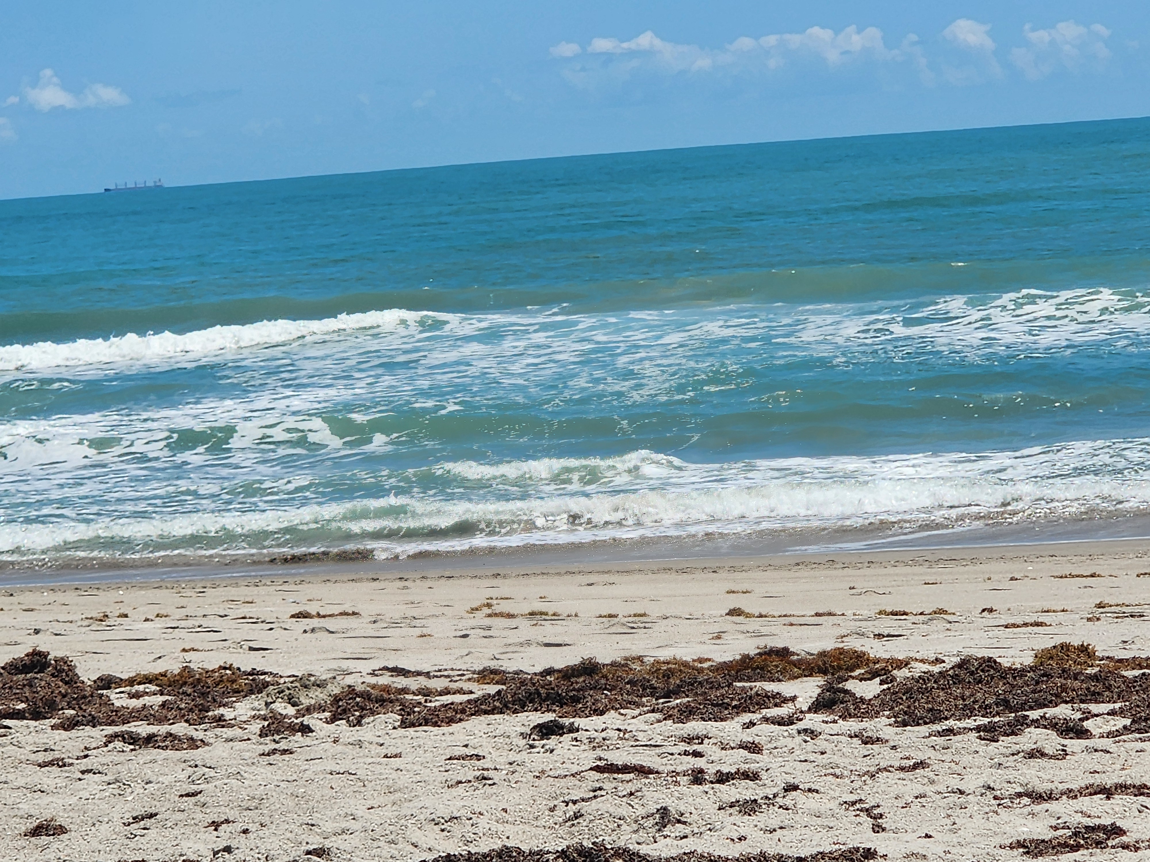Clean small waves breaking nearshore in golden afternoon light at 31st Street Cocoa Beach