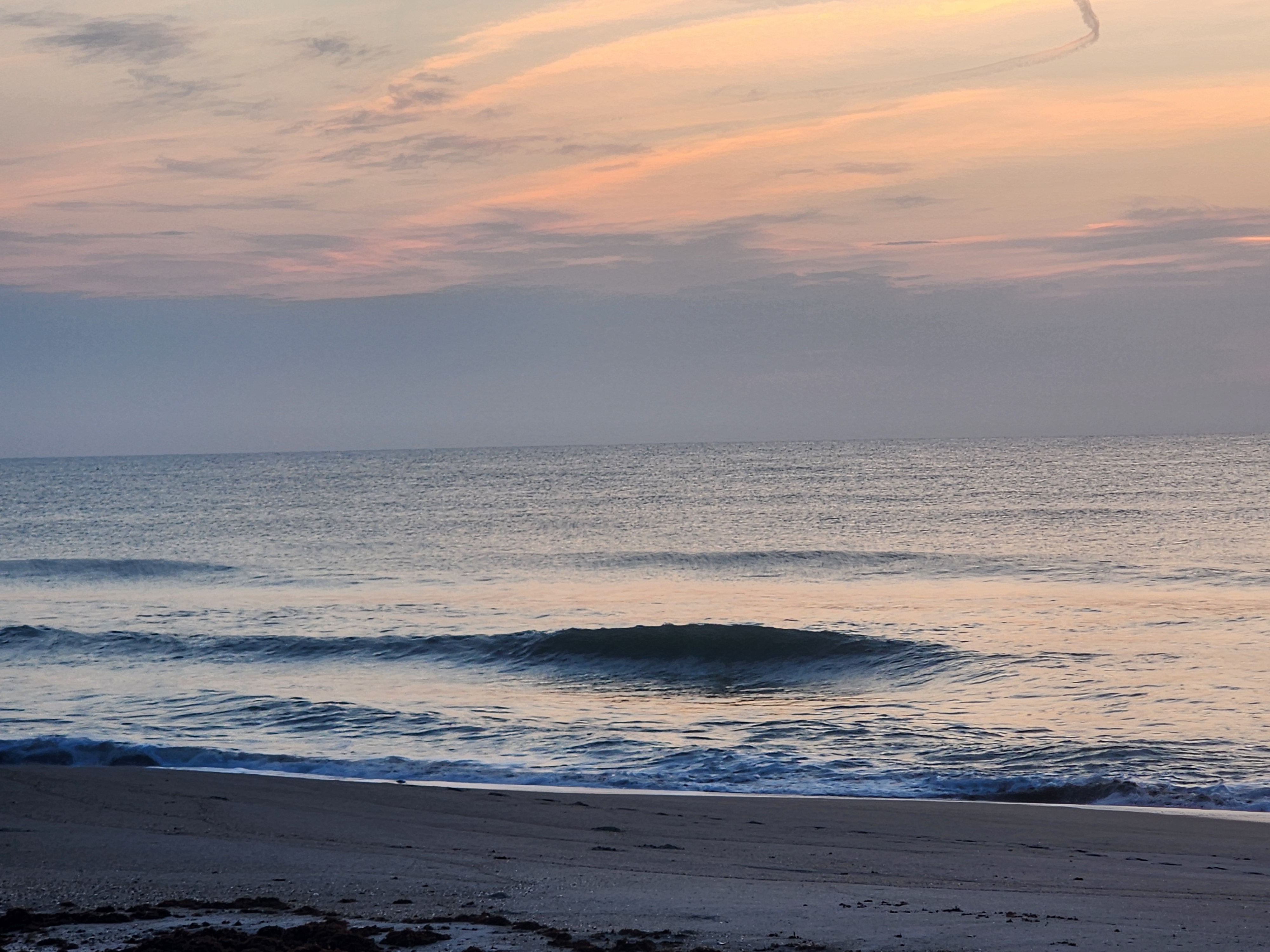 Clean offshore lines rolling in at 31st Street Cocoa Beach with WNW winds grooming the surf
