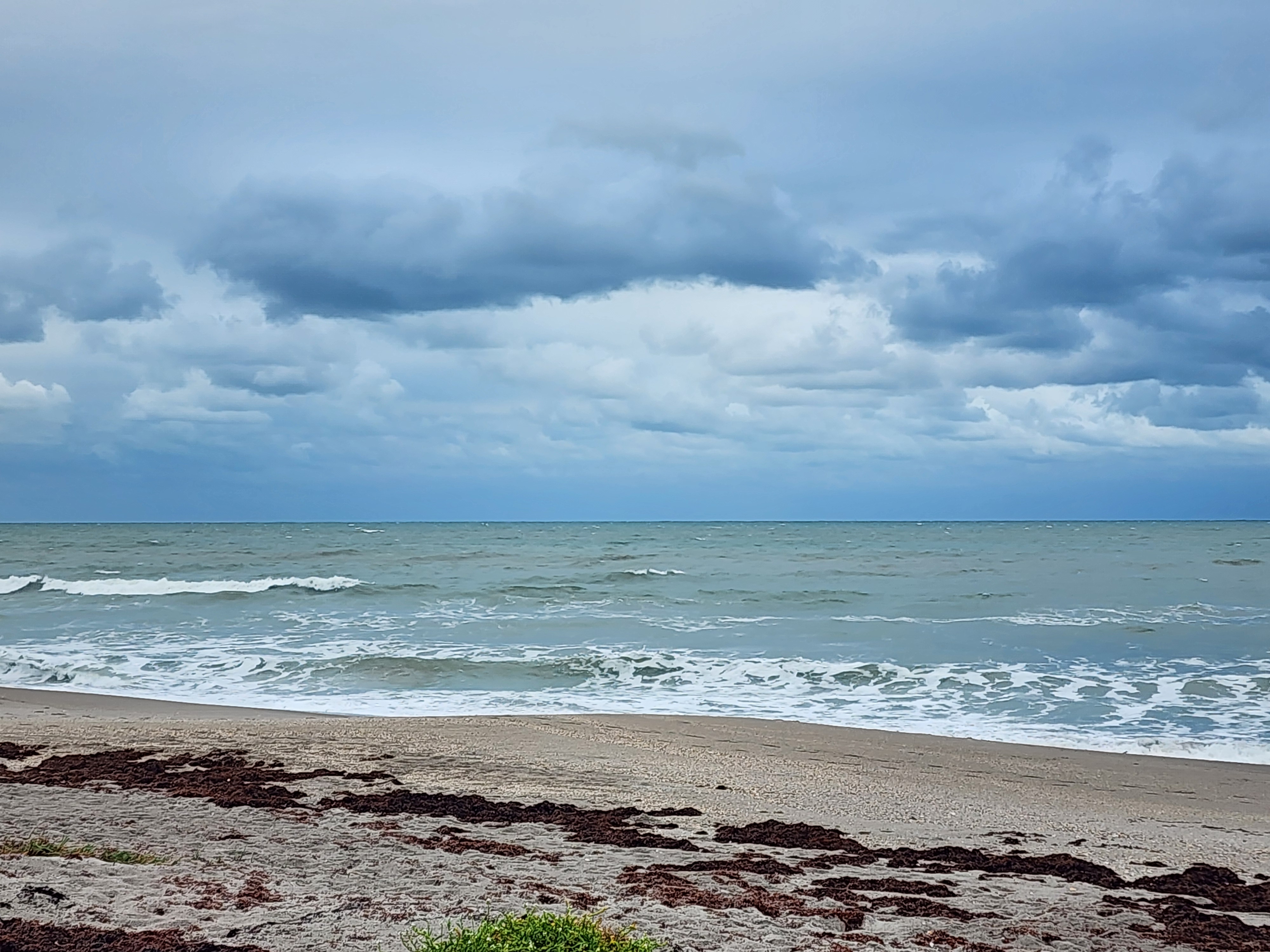 Almost flat ocean with 1 foot wave barely breaking nearshore at Picnic Tables South Cocoa Beach