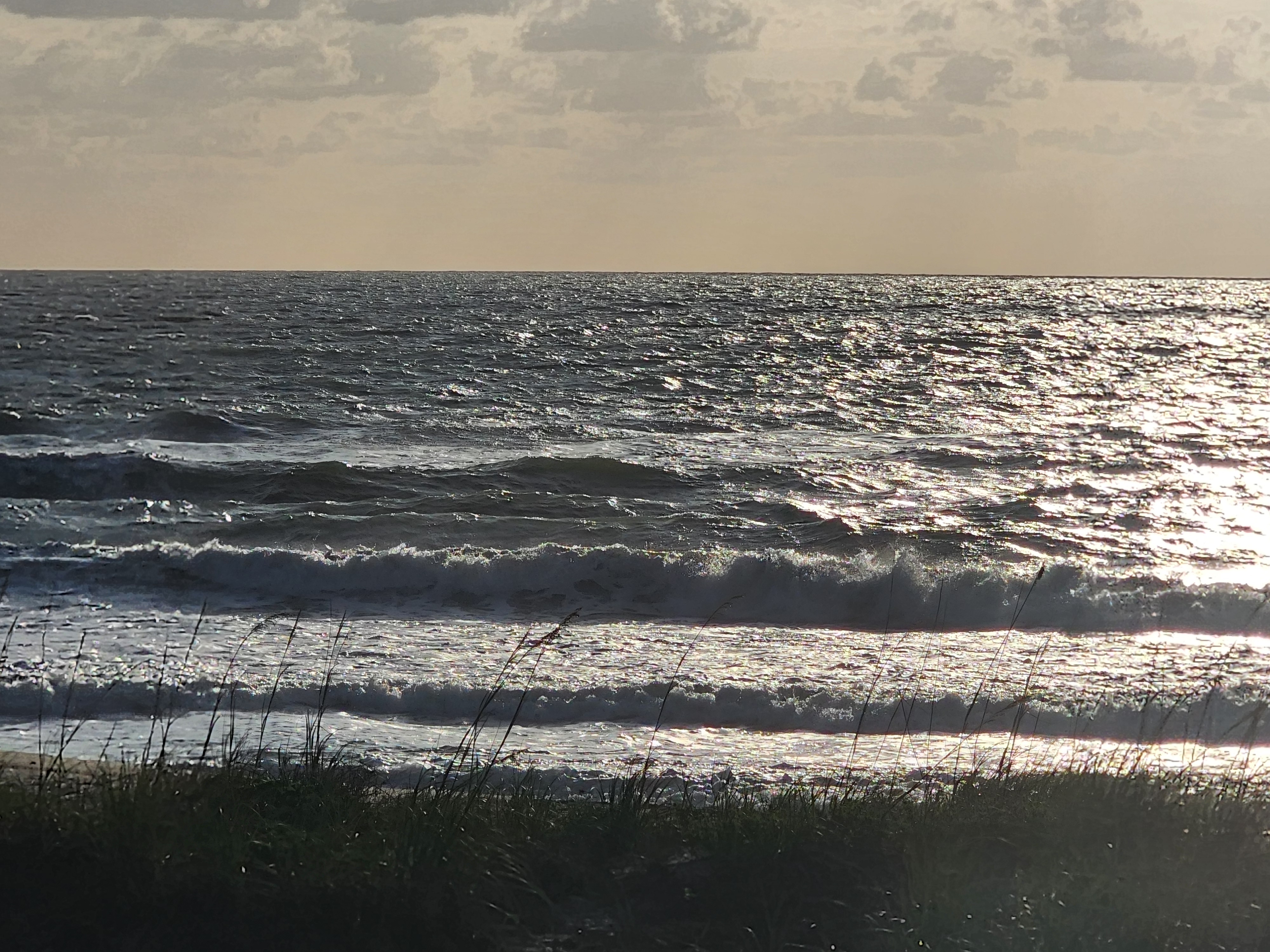 Backlit choppy surf with multiple lines of whitewash through sea oats at Picnic Tables South Cocoa Beach