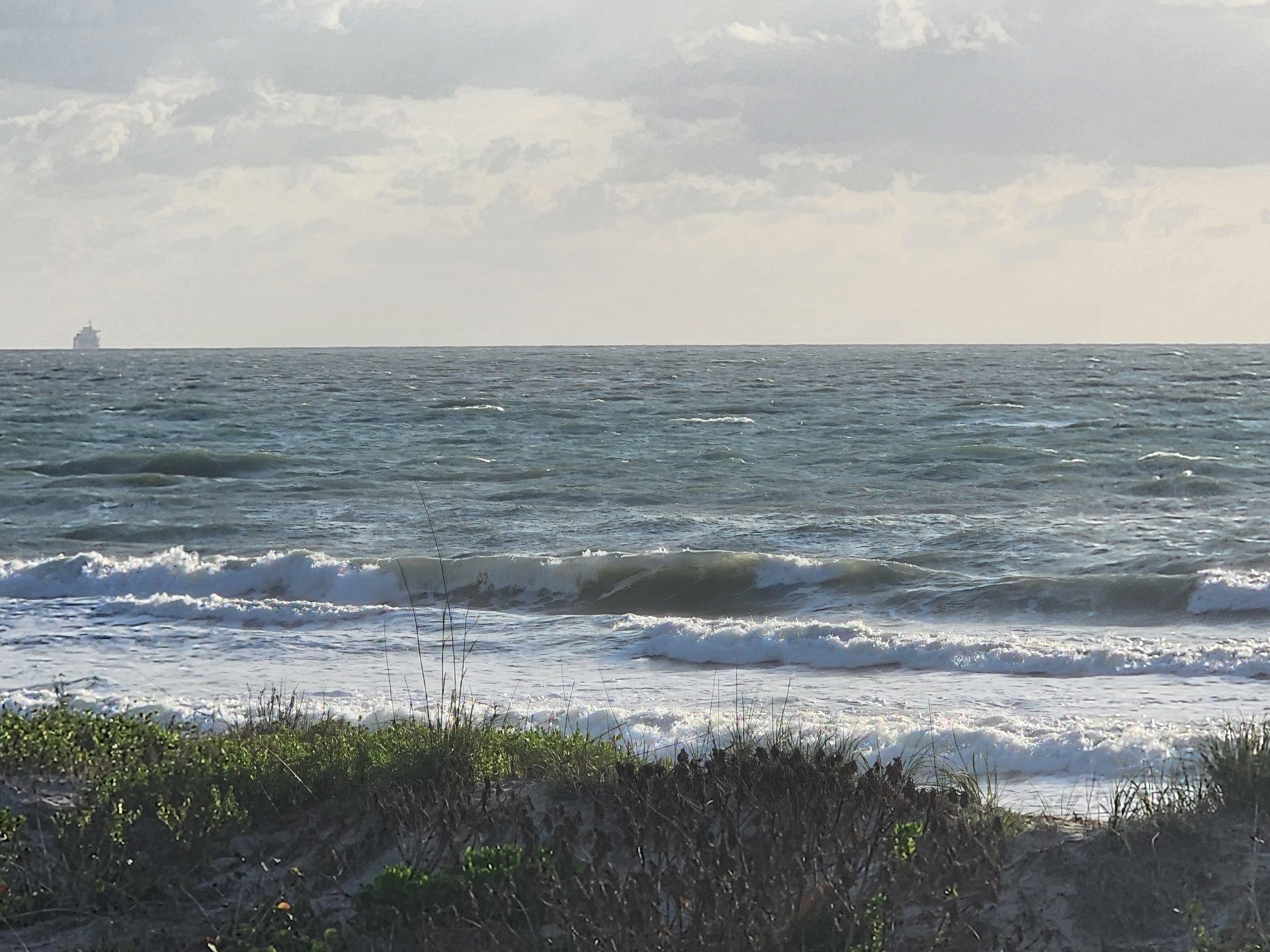 Choppy onshore surf with cargo ship on the horizon at Picnic Tables South Cocoa Beach ENE winds May 4 2026