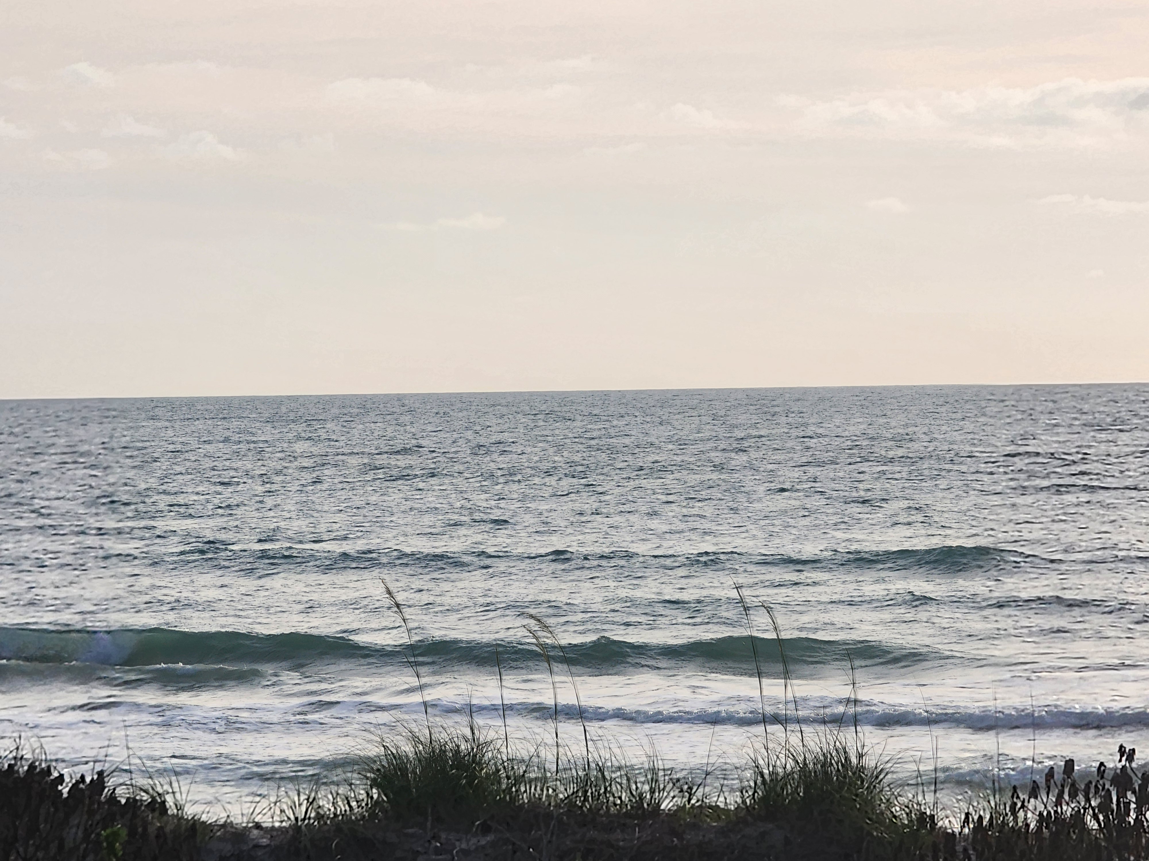 Small clean lines rolling in through the sea oats at Picnic Tables South Cocoa Beach overcast morning