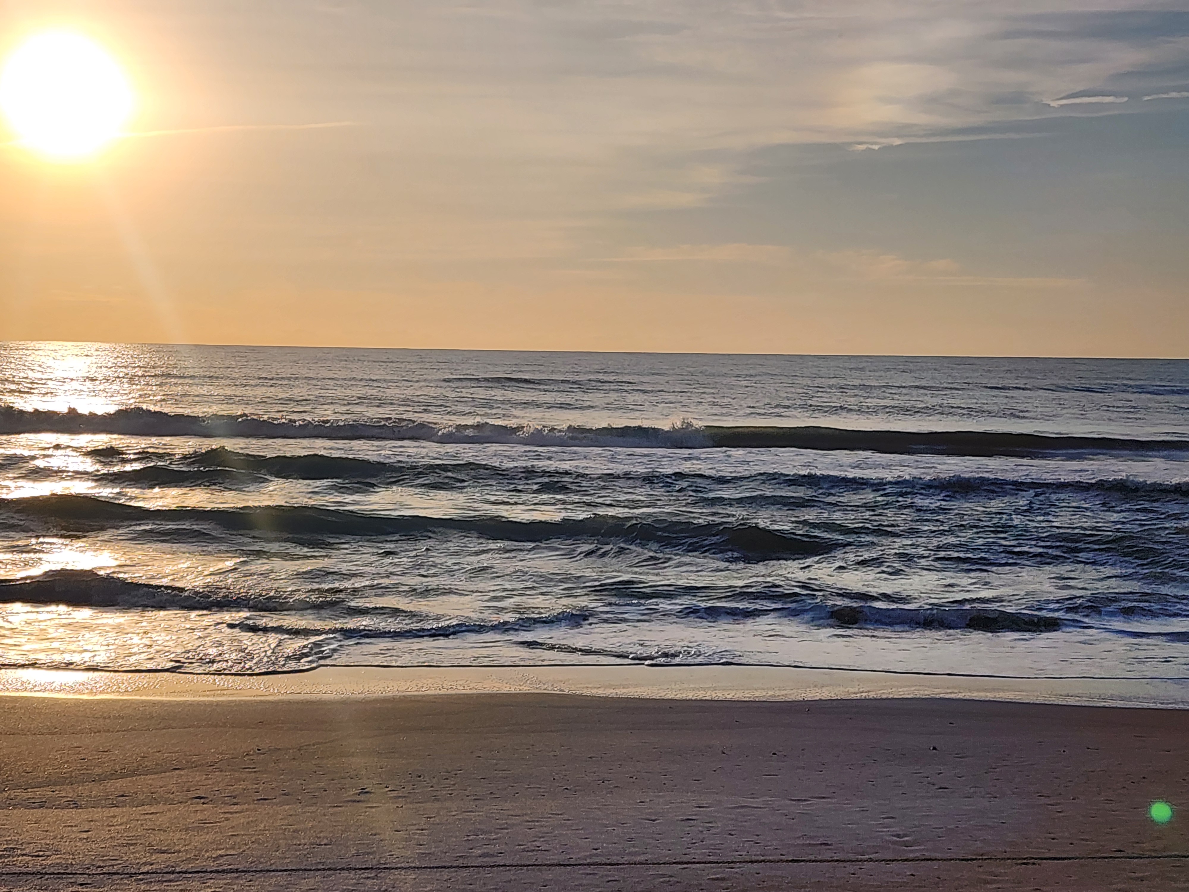Morning golden sun reflecting off small clean waves at Picnic Tables South Cocoa Beach