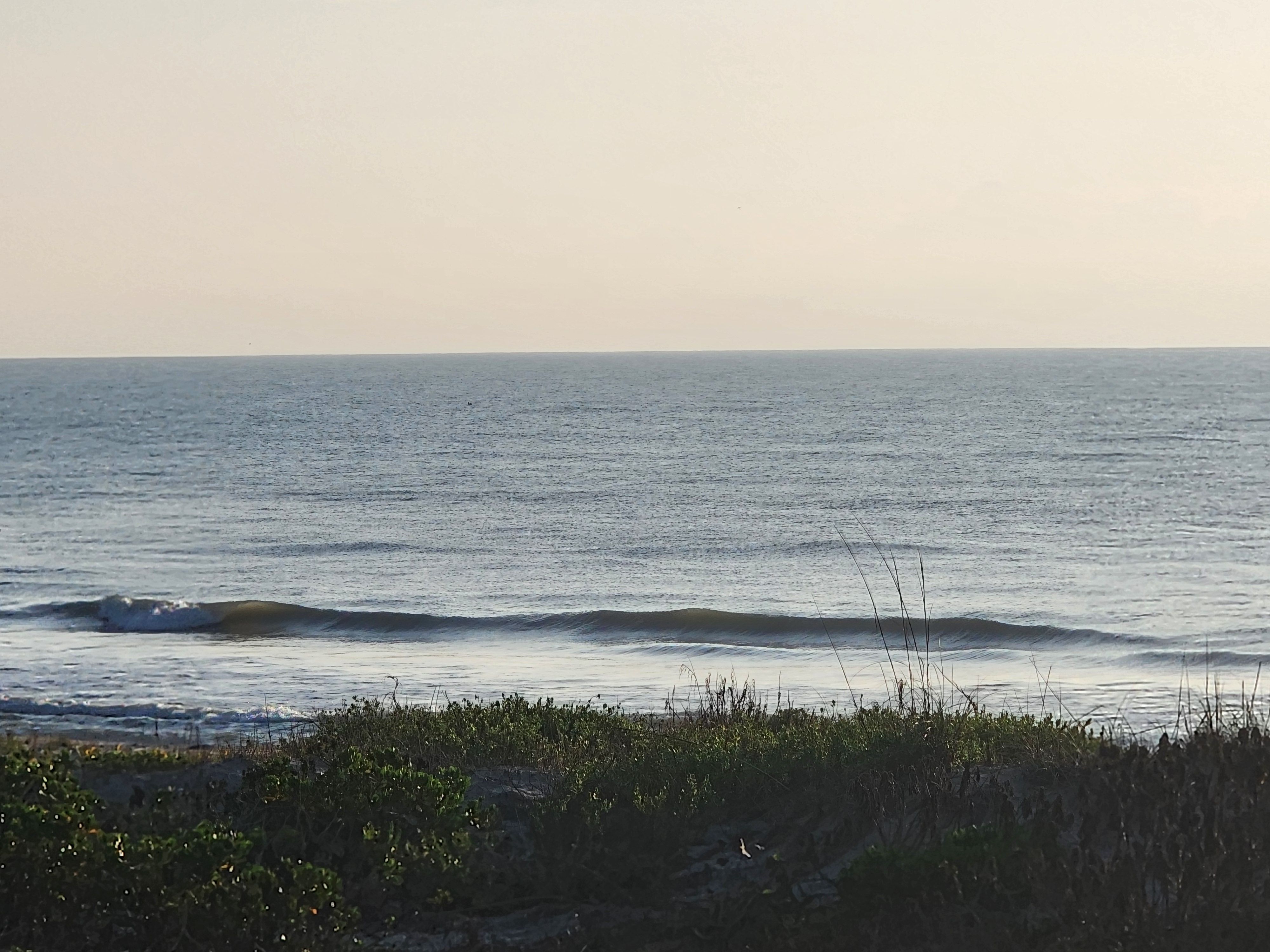 Glassy 1 foot wave with green face breaking left to right over calm flat ocean at Picnic Tables South Cocoa Beach Saturday May 9 2026