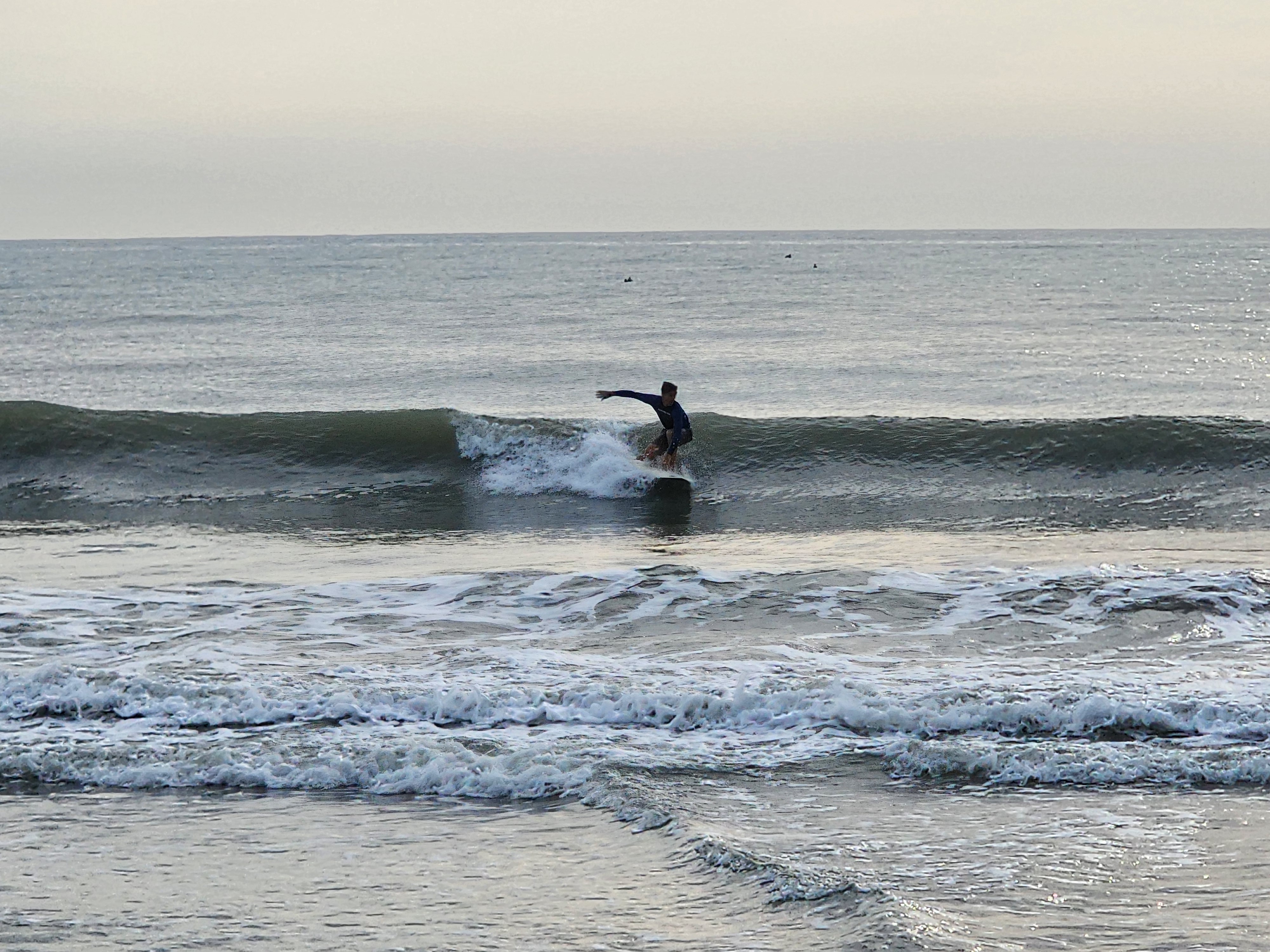 Surfer driving through a clean section with green face and whitewater spray at Picnic Tables South Cocoa Beach SW winds