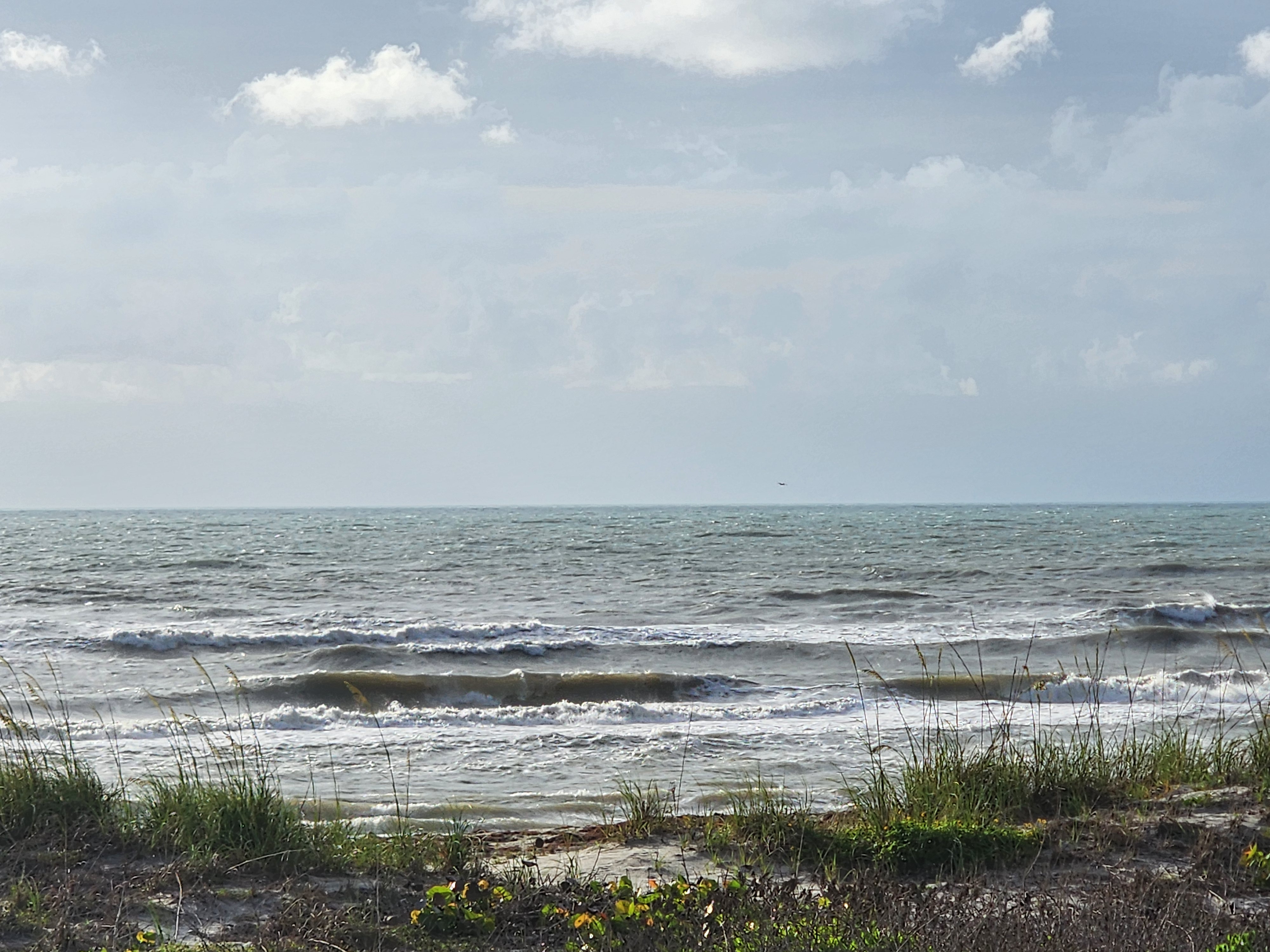 Choppy 2-3 foot wind swell with overcast skies and whitecaps at South Cocoa Beach May 24 2026