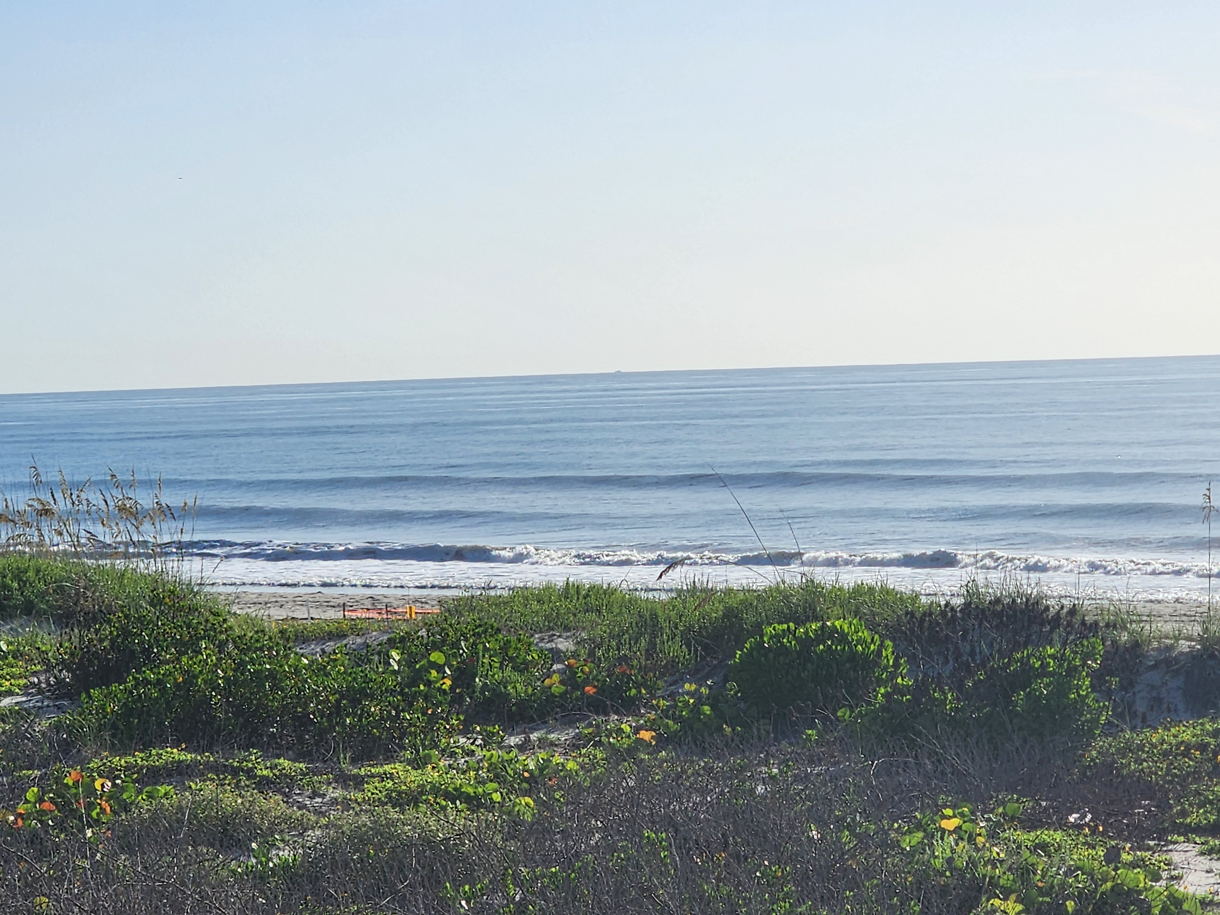 Clean lines rolling in with morning sun reflecting off the water, South Cocoa Beach, July 2026