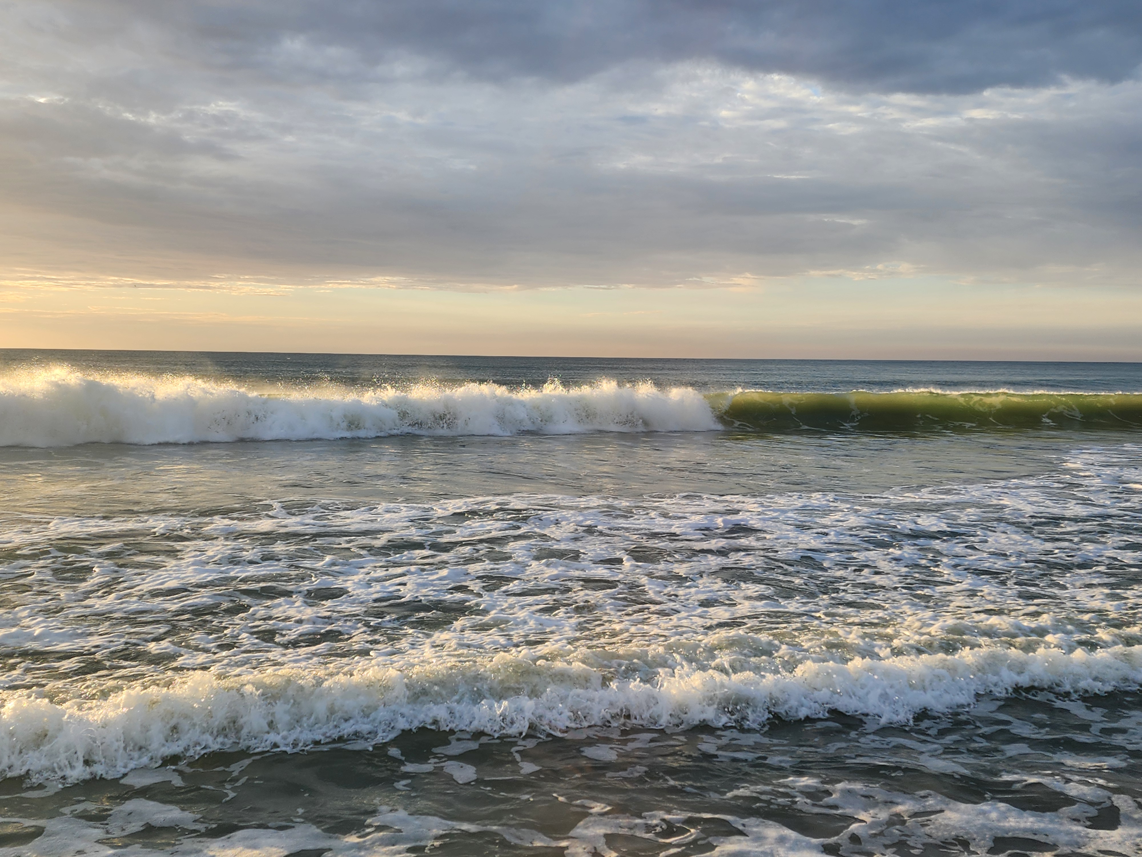 Whitewater wave breaking under a moody, colorful sunrise sky, South Cocoa Beach, July 2026