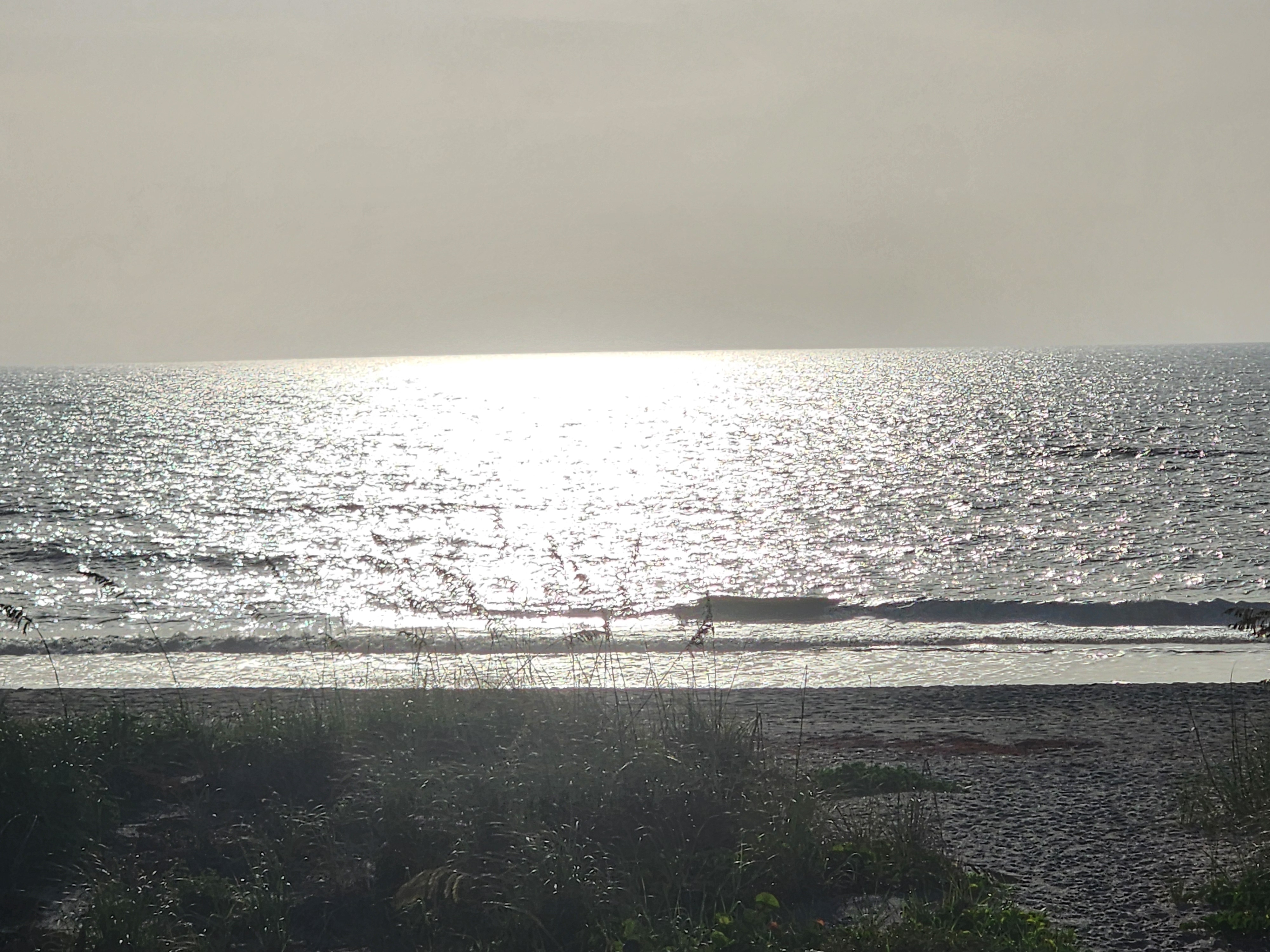 Sun glare over the water with a shorebreak wave, South Cocoa Beach
