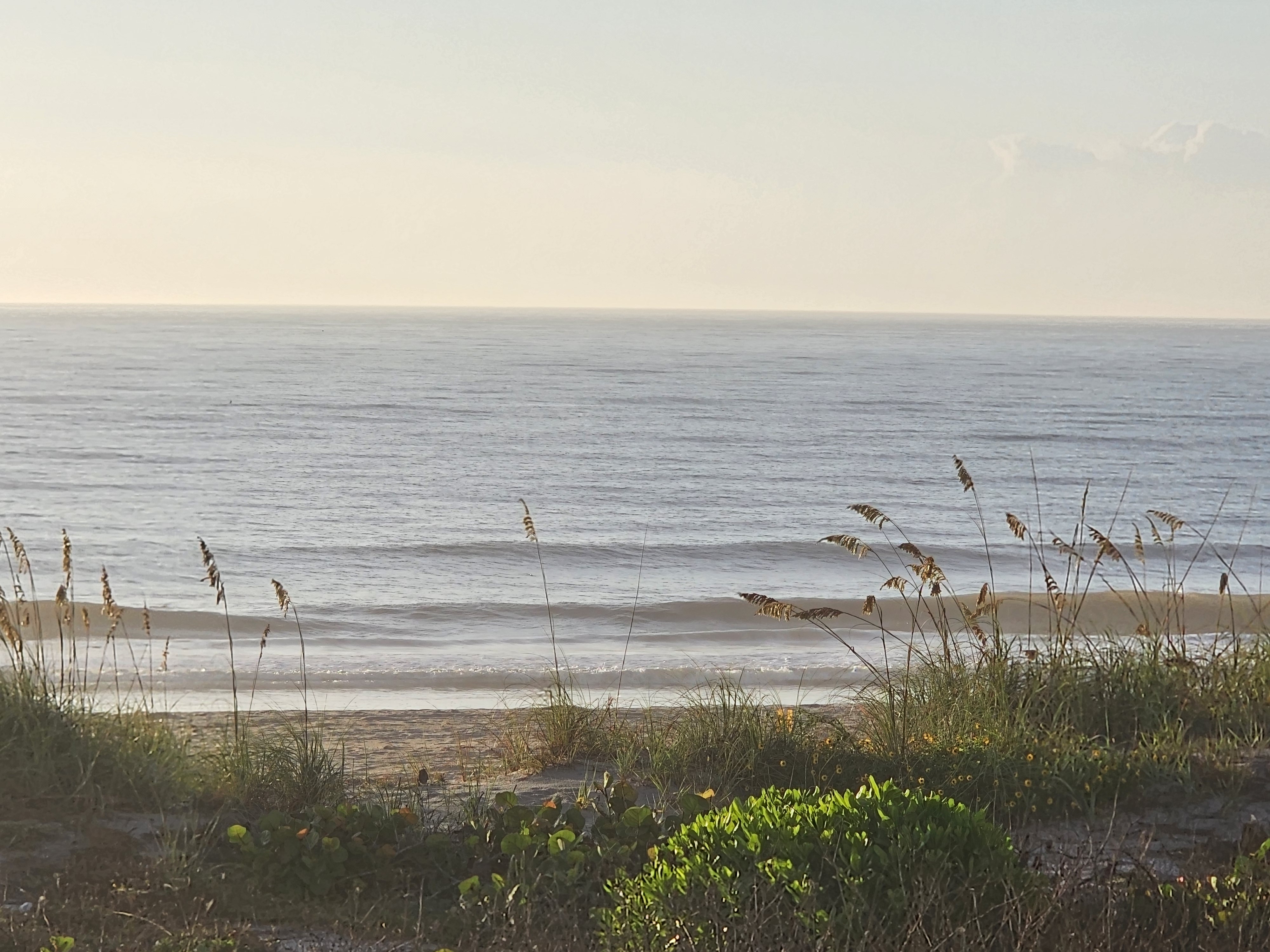 Small waves breaking along the shoreline at 32nd St, Cocoa Beach