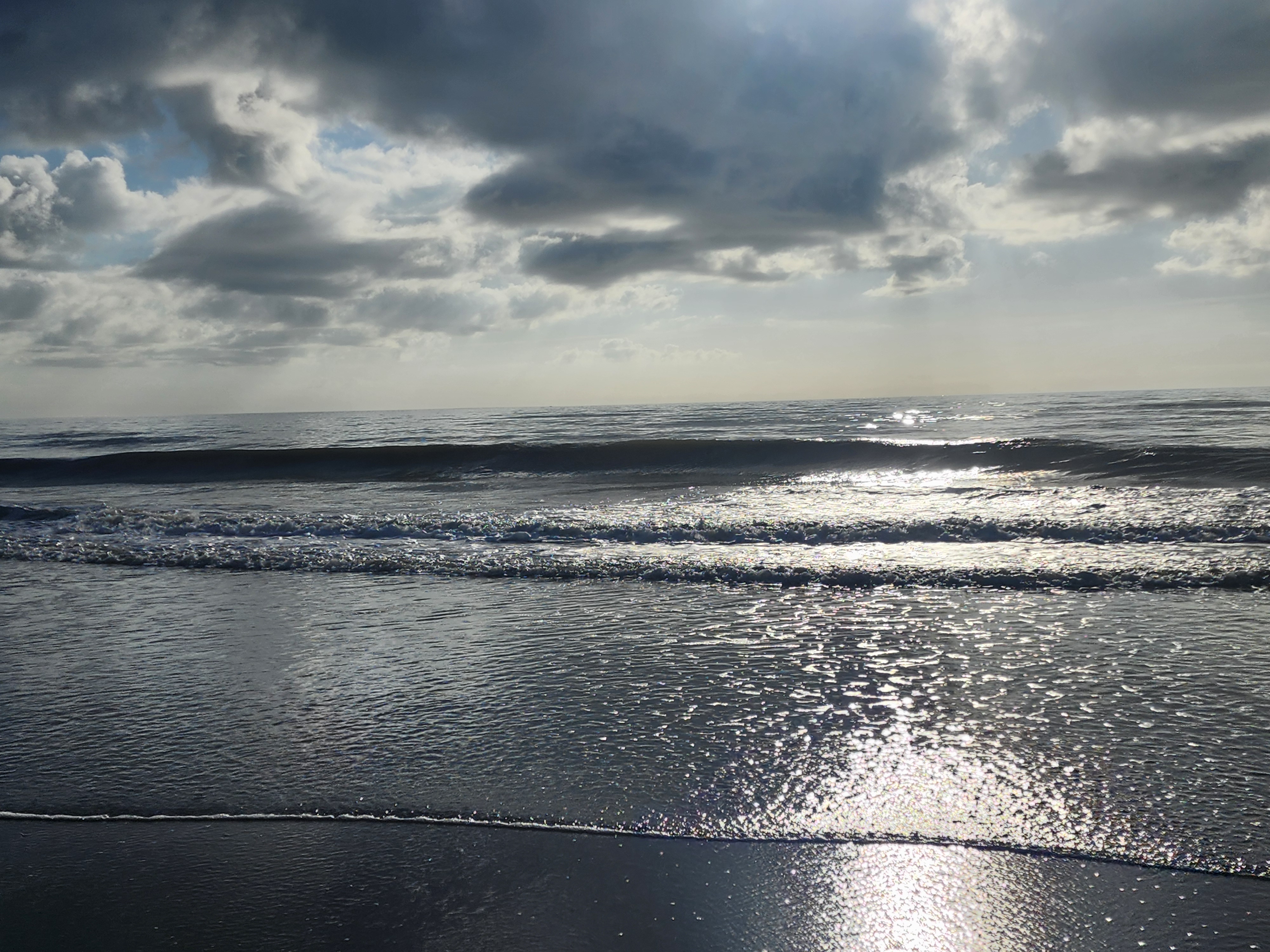 Sun glare sparkling on shorebreak wave, South Cocoa Beach