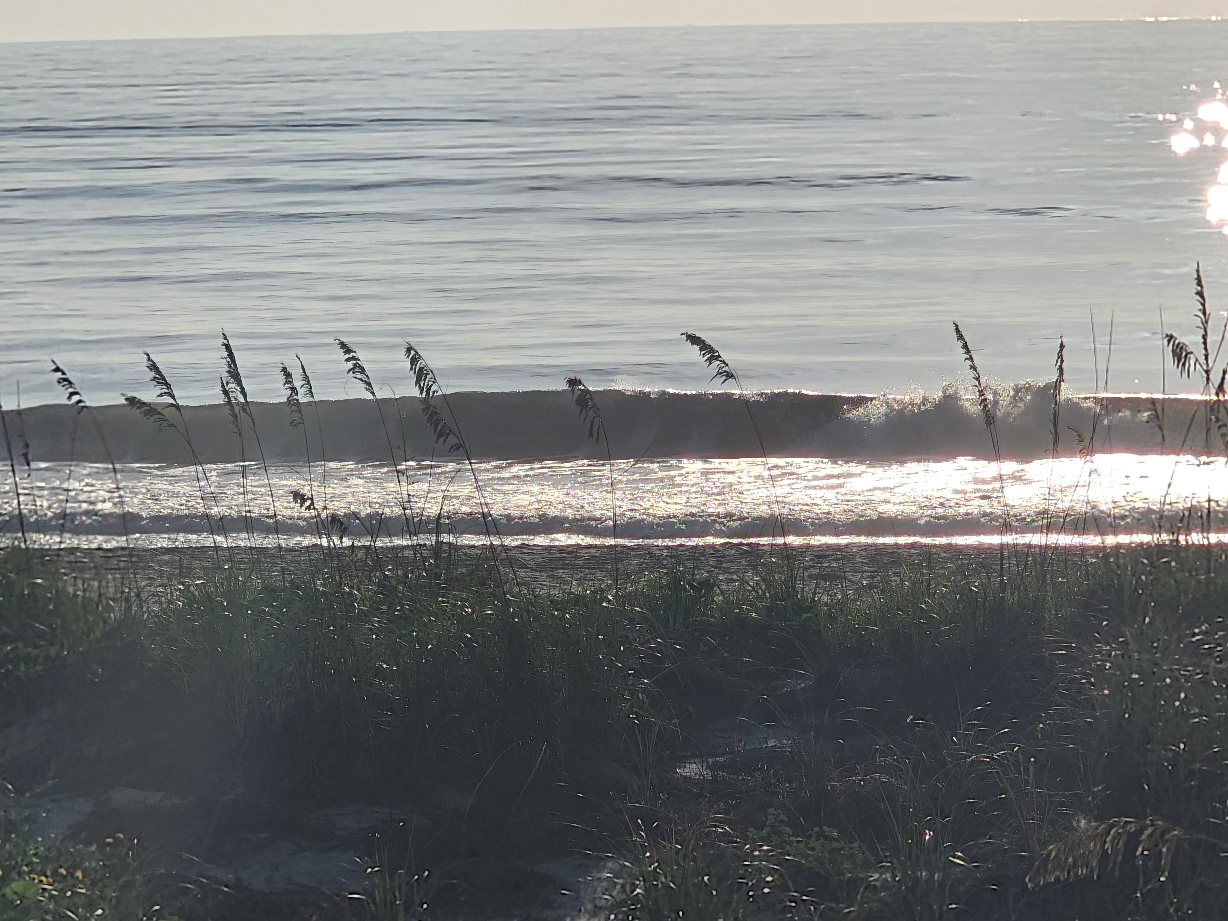 Sun glare sparkling on a breaking wave, South Cocoa Beach