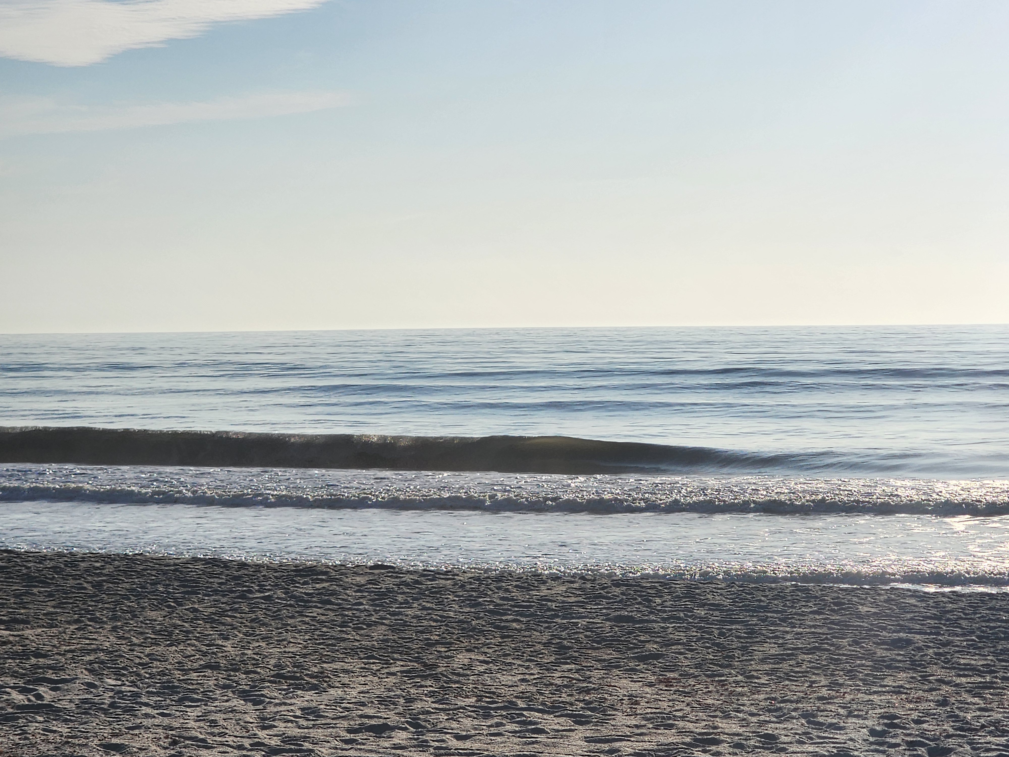 Calm morning swell lines rolling in at mid tide, South Cocoa Beach