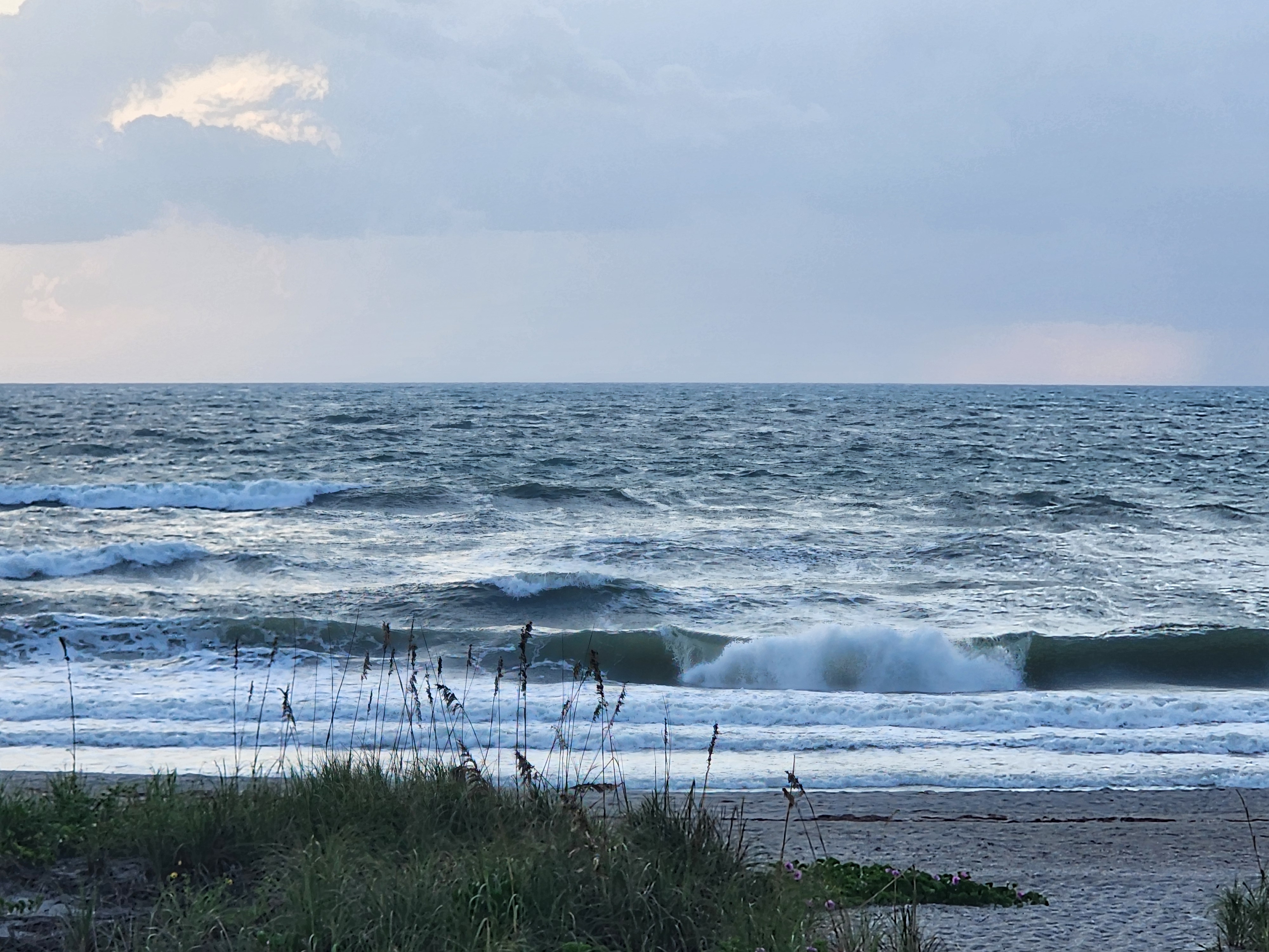 Choppy 3-4 ft surf at Cocoa Beach with a wave pitching on the inside, sea oats and morning glory on the dune at low tide