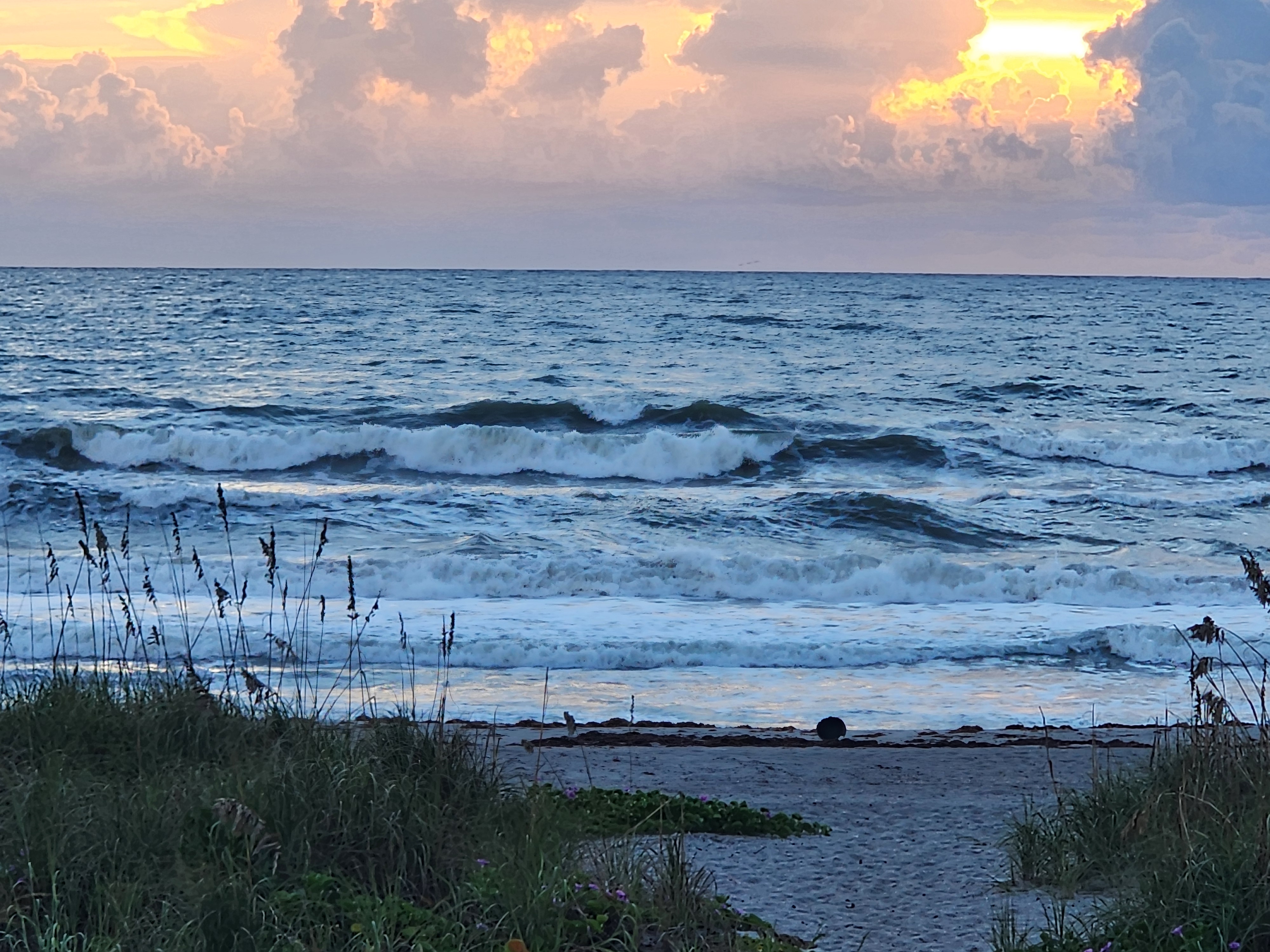 A solid head-high wave throwing out and feathering in the ENE bump, sun breaking gold through the cloud bank over the Atlantic, South Cocoa Beach