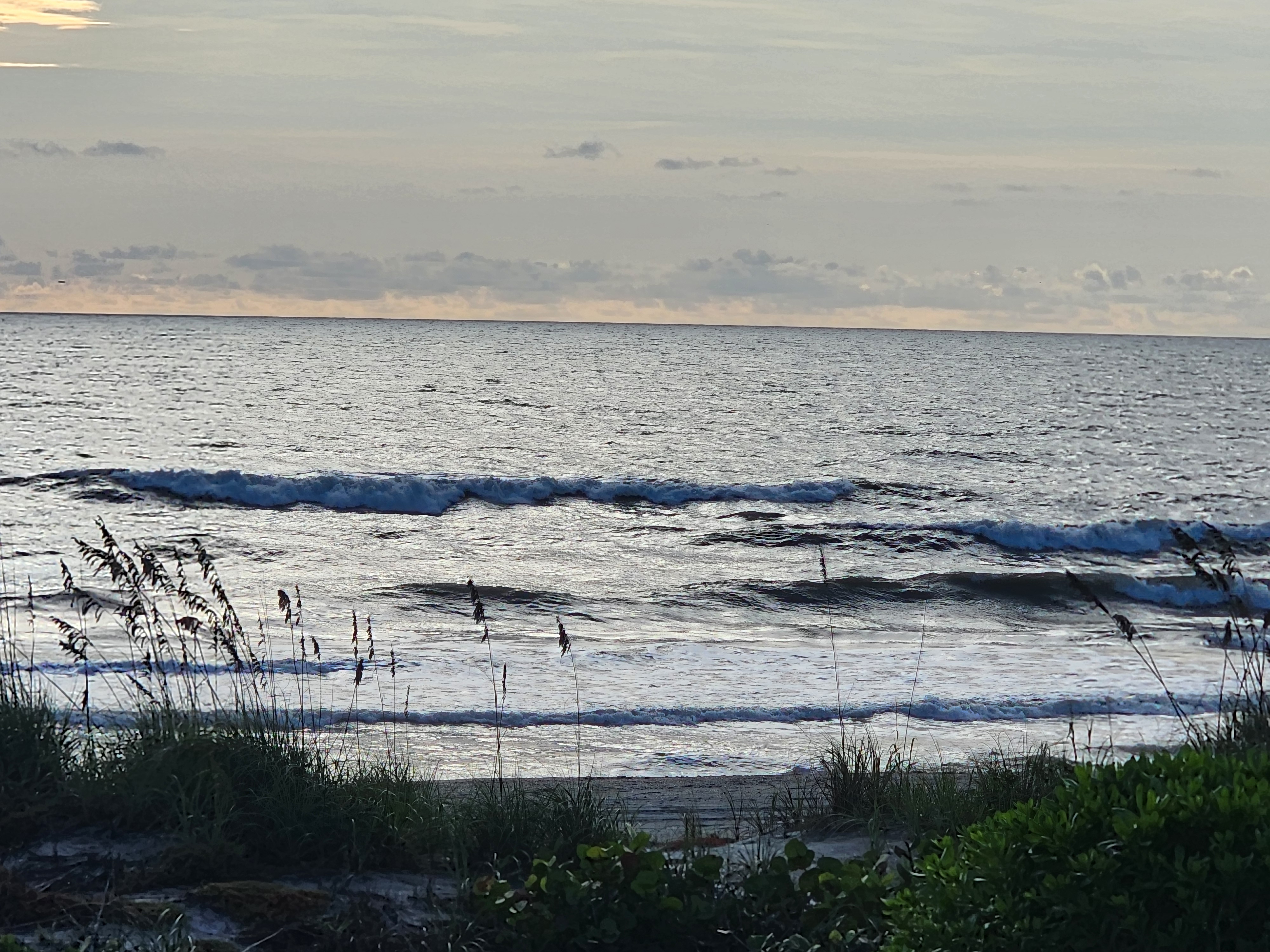 Silvery backlit sets stacking up across the sandbar with a short peak breaking on the outside and smaller lines reforming on the inside