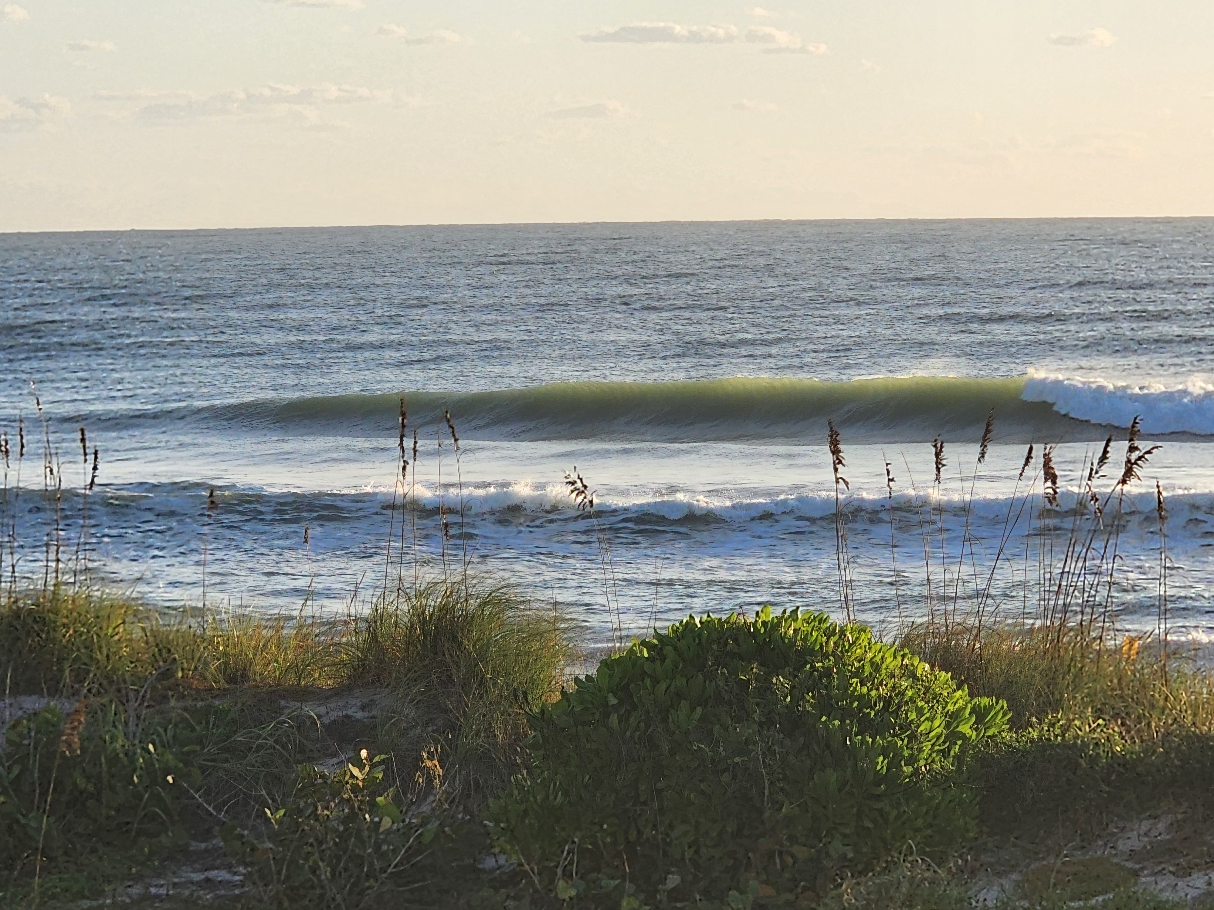 Long green lip running down the line as a set wave begins to break on the right